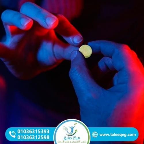 Hand holding a yellow pill.